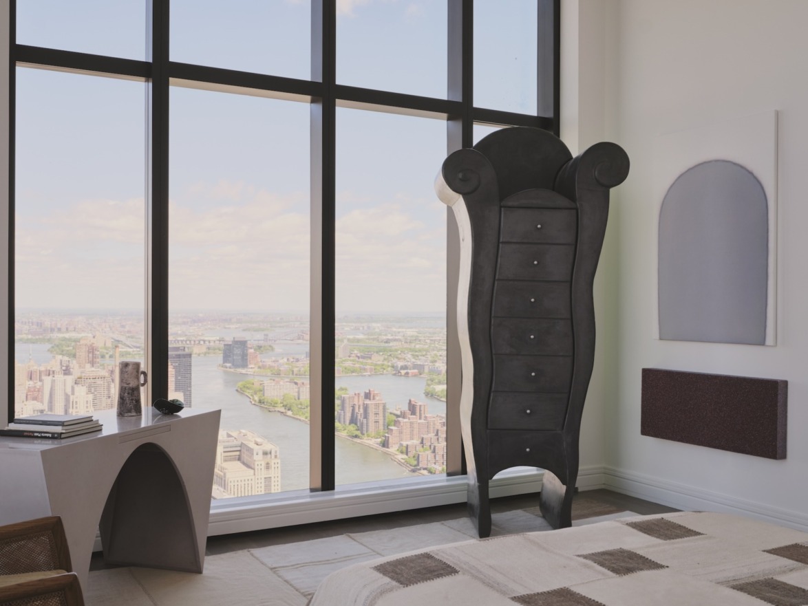 Modern bedroom with unique standing closet, large windows showcasing a cityscape view, and contemporary minimalist decor.