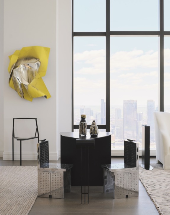 Modern dining area with sleek black table, metallic chairs, large windows, city view, and abstract yellow wall art