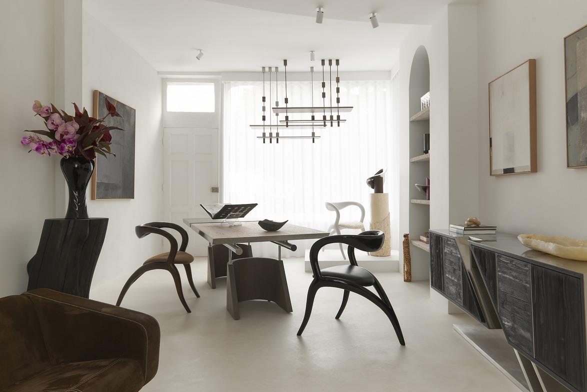 Modern dining room with minimalist furniture, a wooden table, unique chairs, contemporary decor, and a large window.