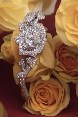 Diamond-encrusted floral bracelet displayed on yellow roses background.