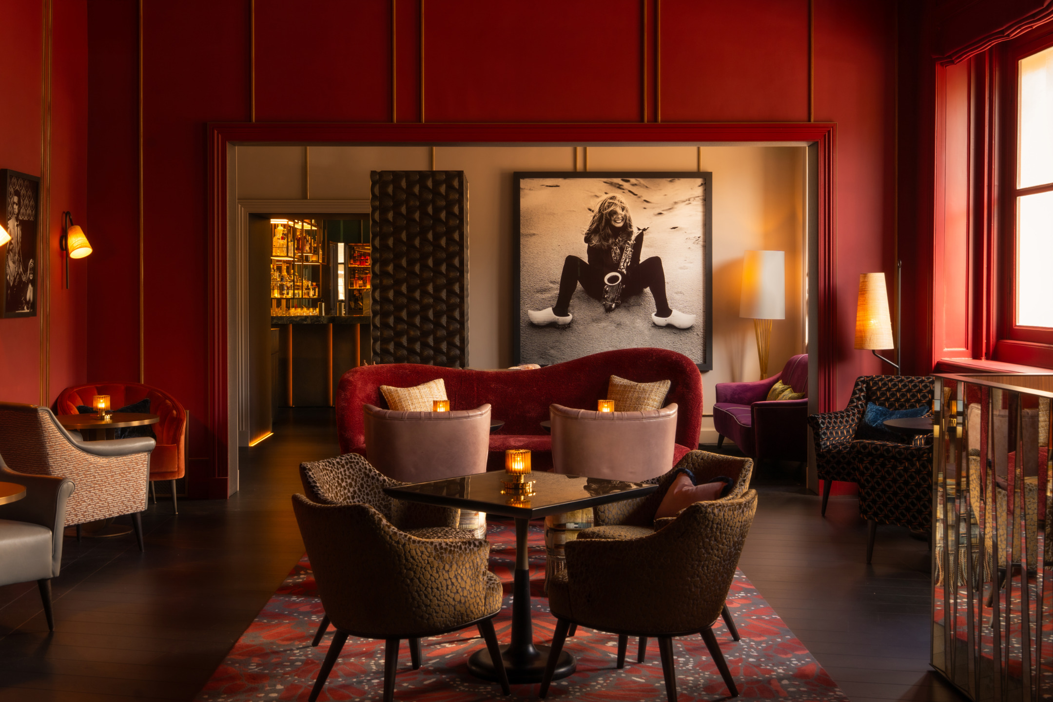 Cozy lounge with elegant seating, warm lighting, and modern art on the walls.