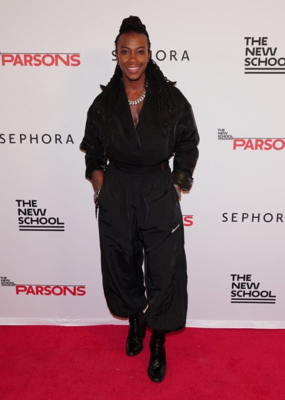 Person in a stylish black jumpsuit on a red carpet at an event, with logos of Sephora and The New School in the background.
