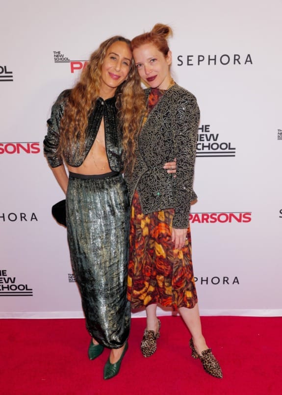 Two people posing together on a red carpet at an event with 'The New School' and 'Sephora' logos in the background.