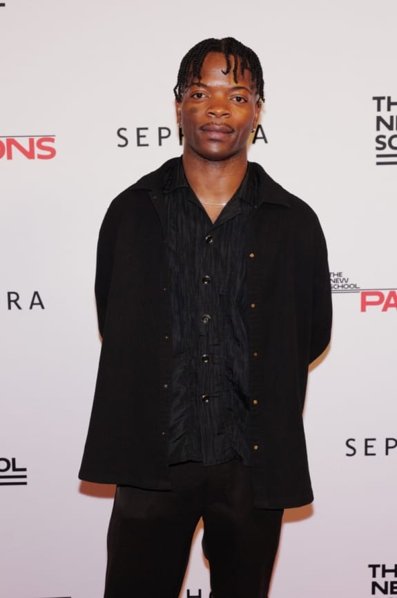 Person posing on a red carpet at an event with Sephora and Parsons branding in the background.
