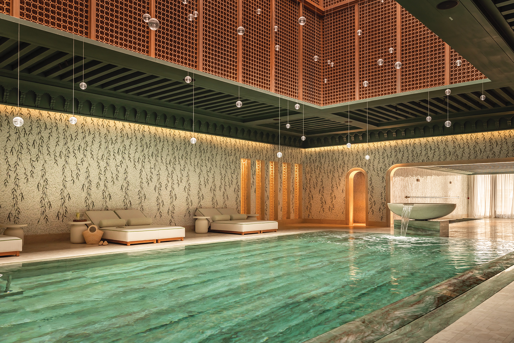 Luxurious indoor pool with comfortable lounge chairs and elegant wooden decor, featuring soft lighting and a tranquil ambiance.