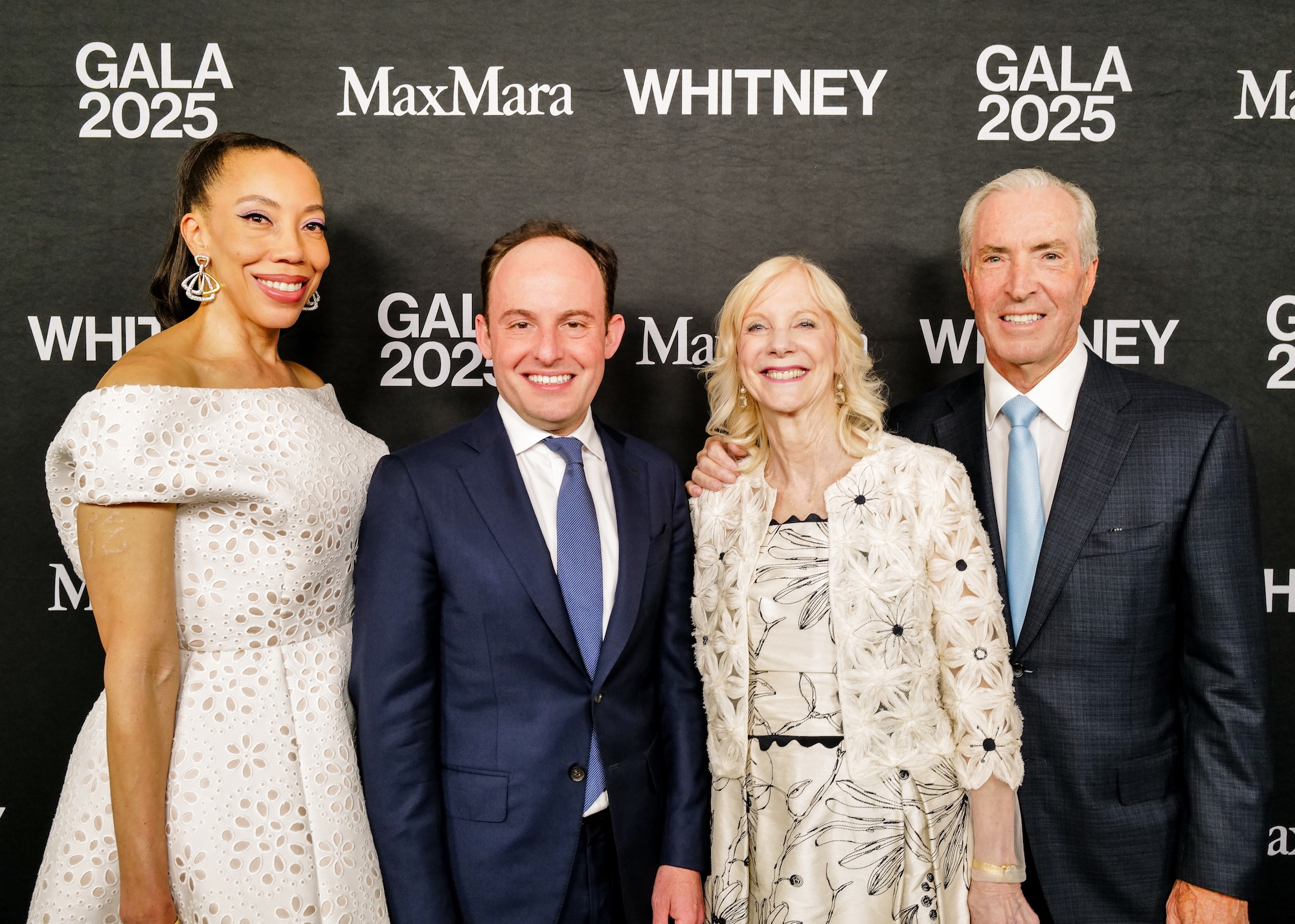 Four people smiling at a Whitney Gala 2025 event backdrop with MaxMara branding.