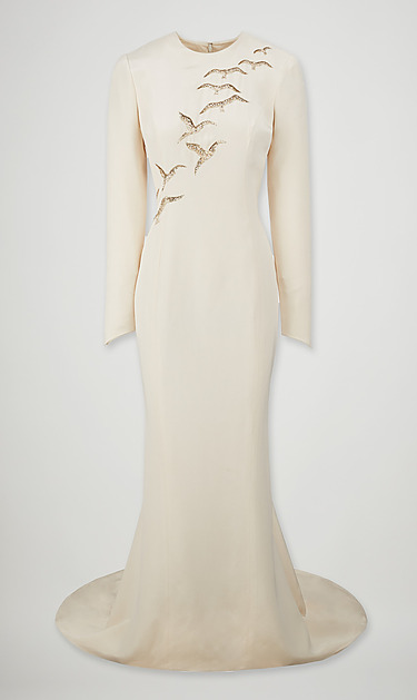 Ivory gown with long sleeves and bird embellishments on the shoulder, featuring a flowing train.