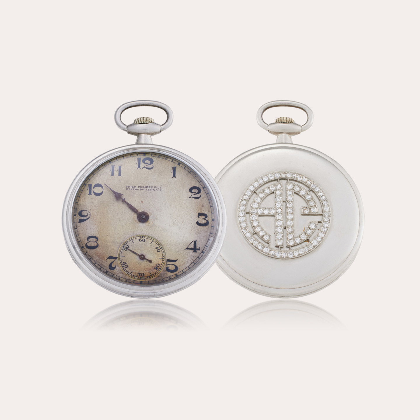 Vintage pocket watch with an ornate pearl and diamond back, featuring classic numerals and an elegant design.