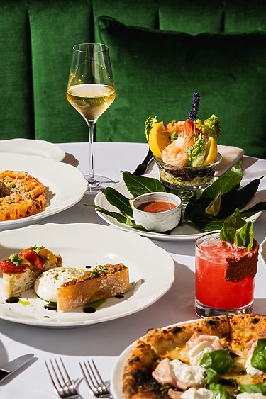 Assorted gourmet dishes and drinks on a table with vibrant colors and elegant presentation.