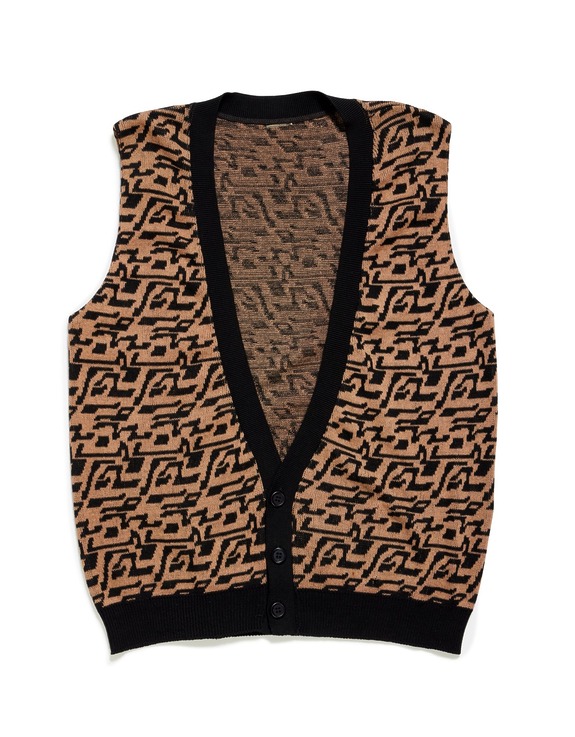 Knitted sleeveless vest with black and beige geometric patterns and black trim on a white background.