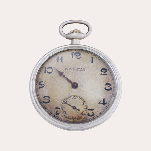 Vintage pocket watch with visible numbers and minute hand against a plain background.