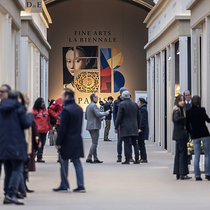 Visitors at an art exhibition with a large wall display in the background featuring abstract and classic art elements.