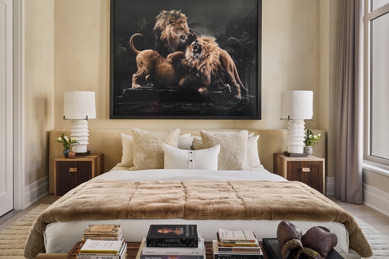 Luxurious bedroom with a large lion artwork above a plush bed, flanked by wooden nightstands and modern lamps.