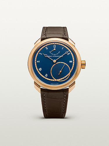 Luxury wristwatch with a blue dial, gold casing, and brown leather strap displayed on a light background.