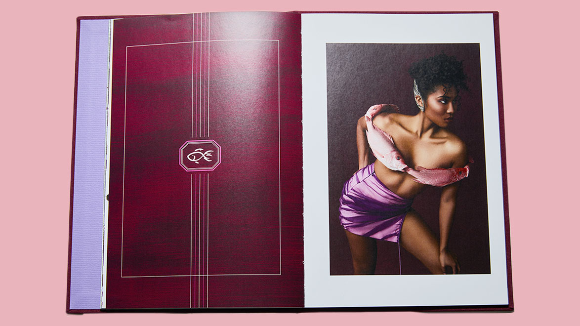 Open book with a portrait photo of a person in a pink outfit on the right page, and a patterned design on the left page.