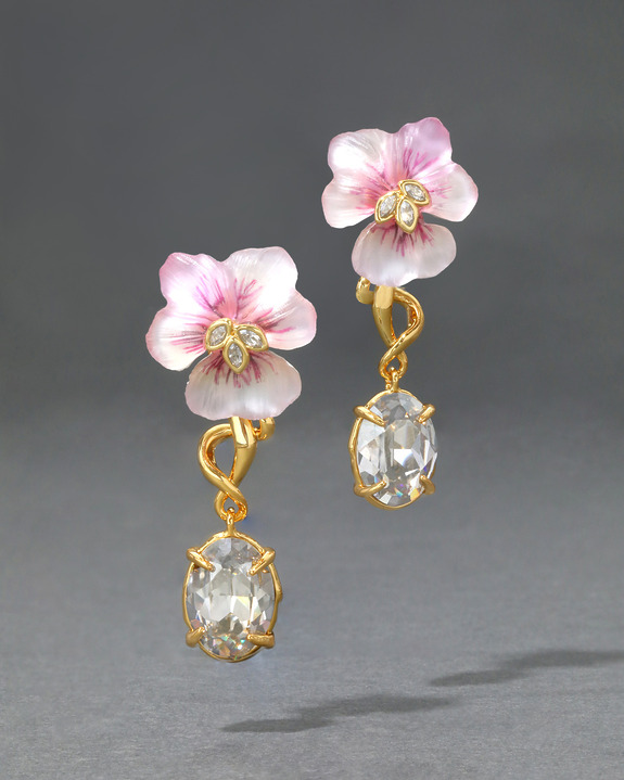 Gold earrings with pink flower motifs and large faceted gemstones on a gray background.