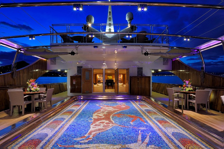 luxurious yacht deck at night with elegant lighting, flower arrangements, and a colorful mosaic floor design