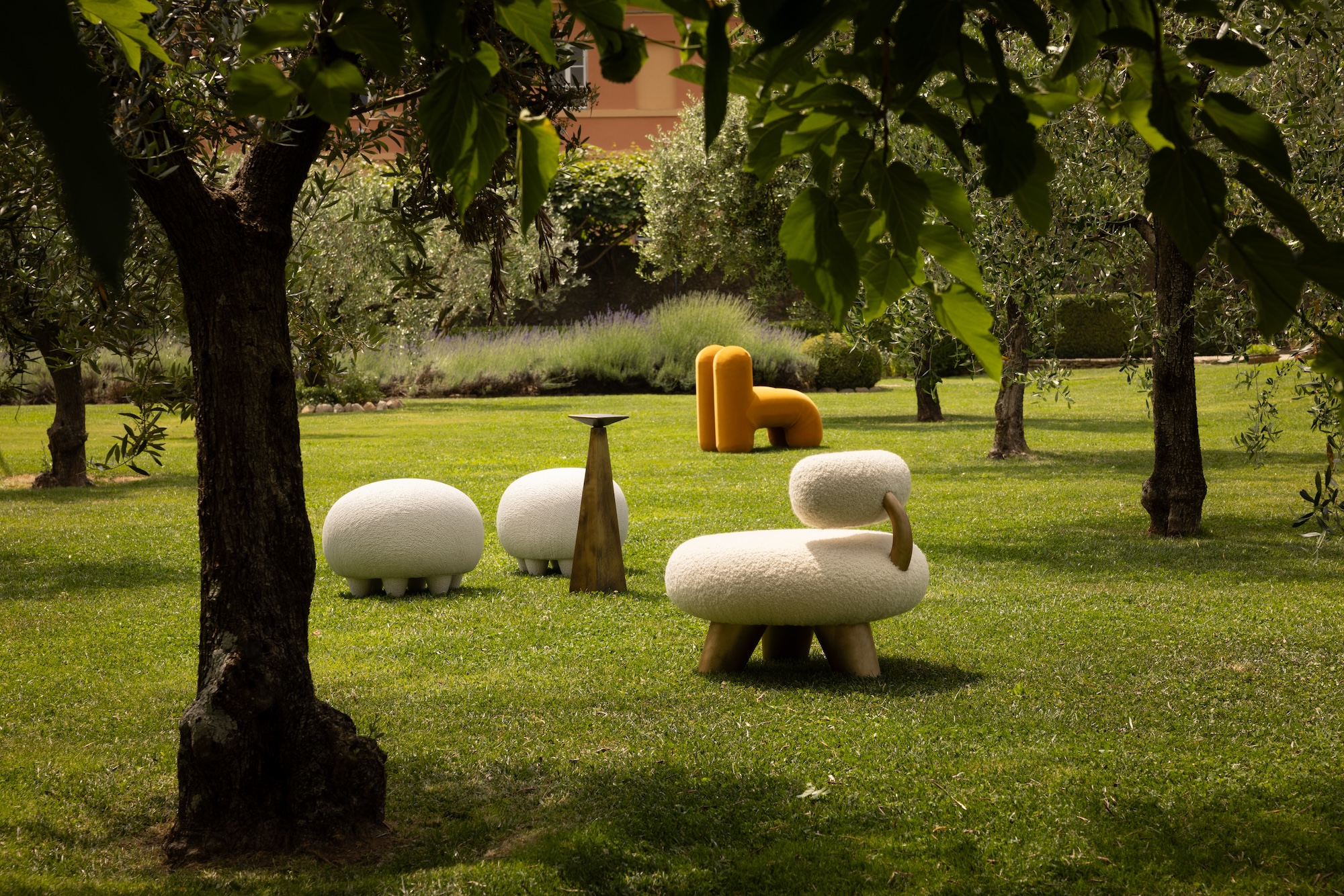 Modern outdoor furniture set on lush green lawn surrounded by trees and shrubs with a peaceful garden atmosphere