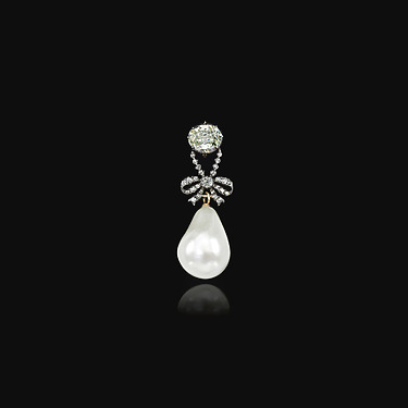 Elegant teardrop pearl earring with diamond accent on a black background.