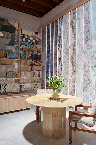 modern showroom with wallpaper samples, a round table, and two chairs