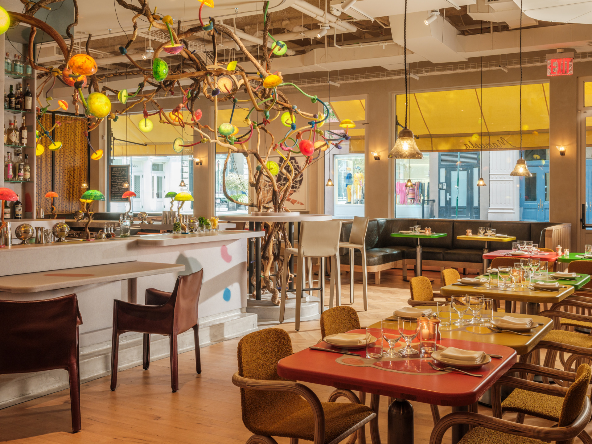 Colorful, modern restaurant interior with eclectic lighting and vibrant table settings.