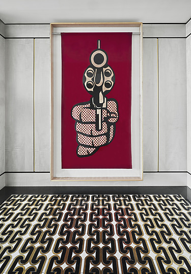 Futuristic artwork of a hand holding a stylized object on a red canvas, displayed above a modern black and white patterned floor.