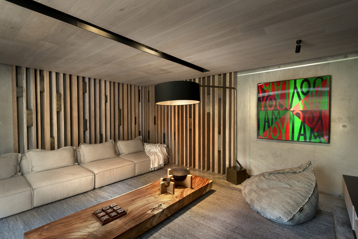 Modern living room with wooden accents, a beige sofa, abstract art on the wall, and a low wooden coffee table.