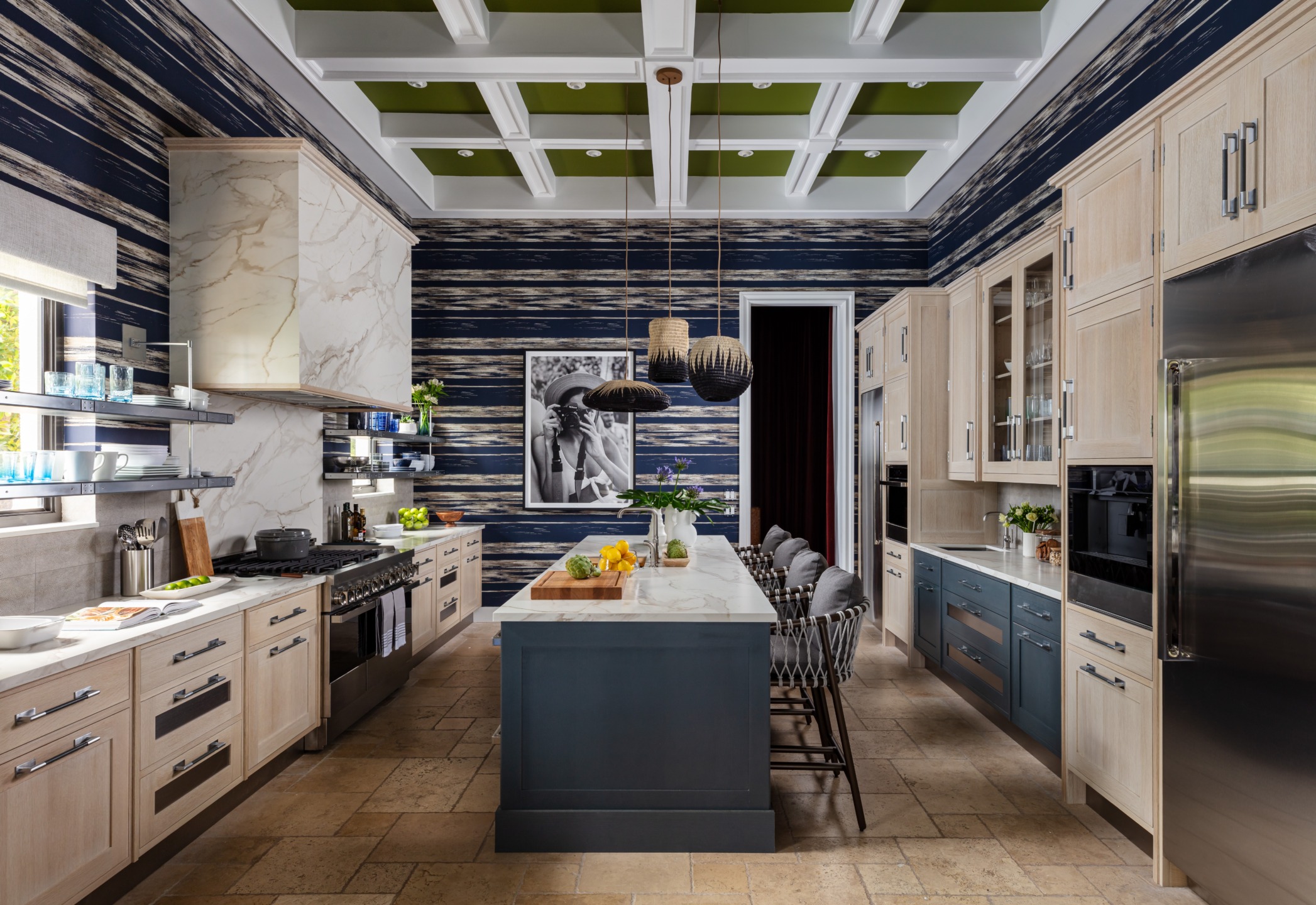 Modern kitchen with navy and wood accents, featuring a large island, pendant lights, and marble countertops.