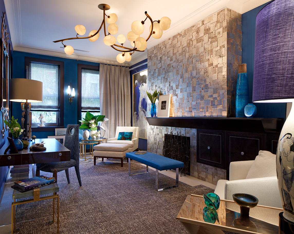 Modern living room with blue accents, textured wall, stylish lighting, and contemporary furniture.