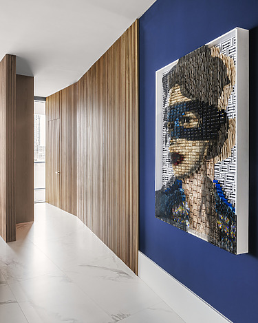 Artwork of a woman with a mask on a blue wall in a modern hallway with wooden paneling and white tiled floor