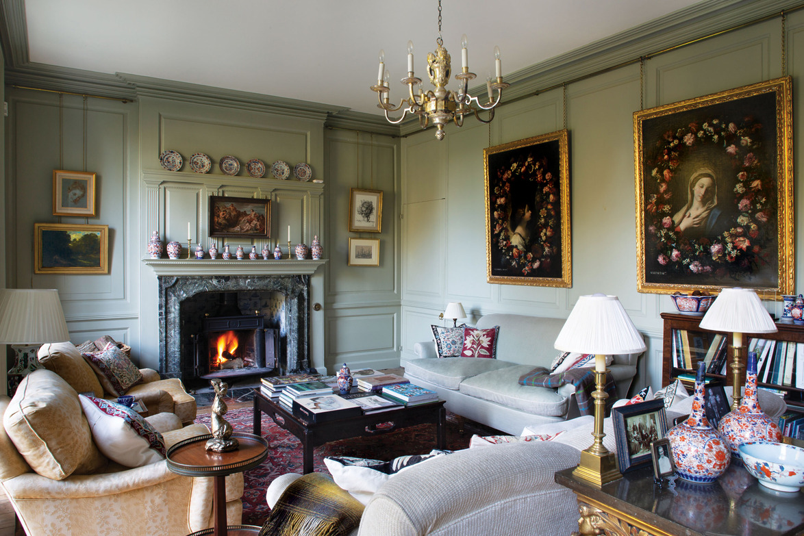 Elegant living room with classic decor, comfortable seating, a fireplace, wall art, and a chandelier.