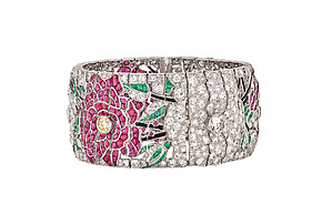Intricate silver bracelet with floral design featuring pink and green gemstones and sparkling diamonds.