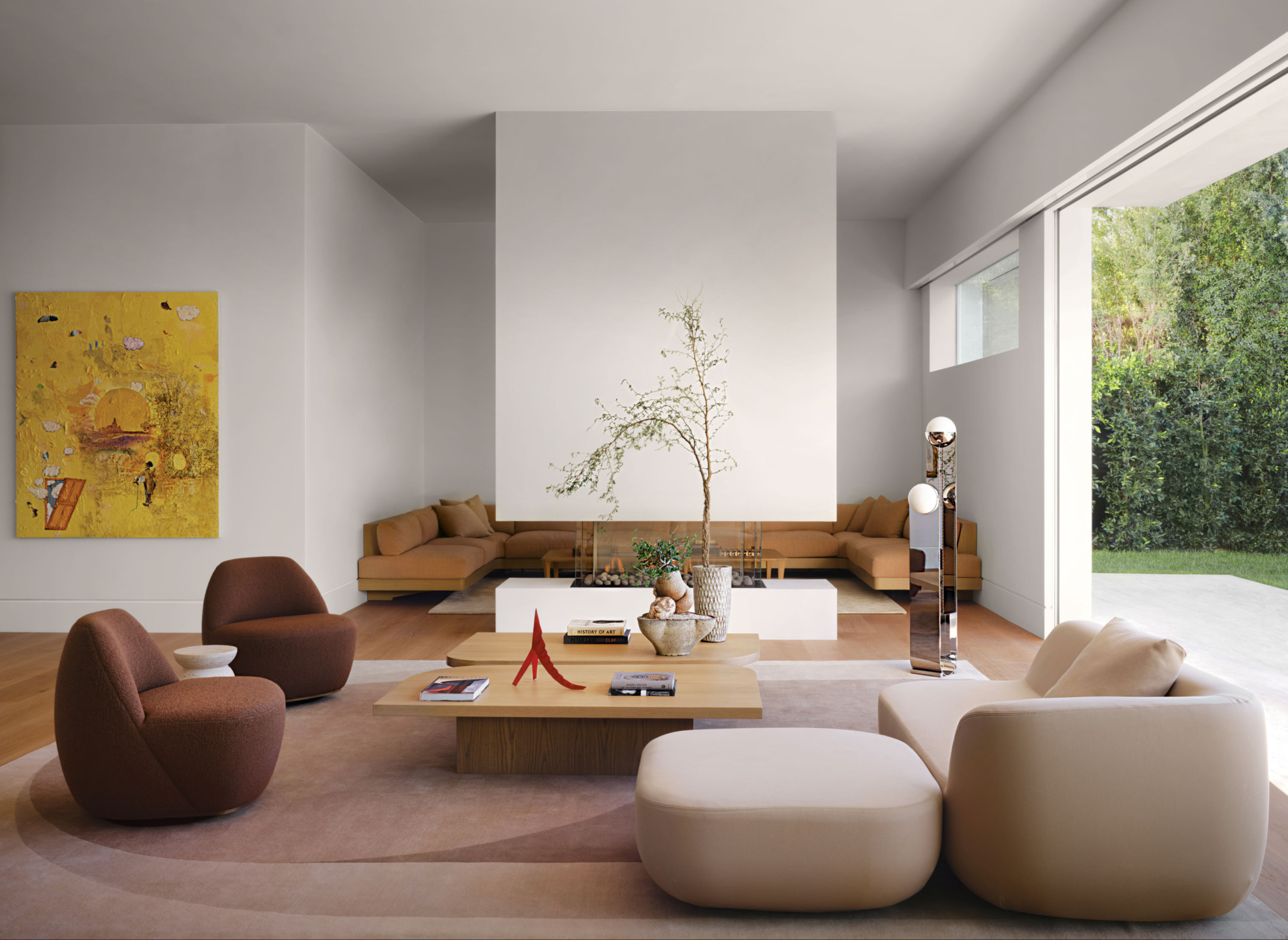 Modern living room with beige sofas, round chairs, a central coffee table, and a large window overlooking a garden.