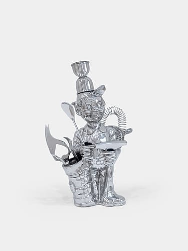 A shiny metal sculpture of an animated character holding an object with various tools and items integrated into its design.