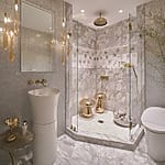 Luxurious bathroom with marble floors, glass shower, modern fixtures, elegant lighting, and decorative wall patterns.