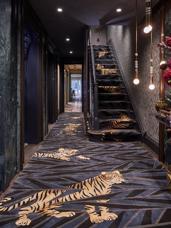 A luxurious hallway with tiger-patterned carpet running up the stairs and along the floor, adorned with hanging lights.