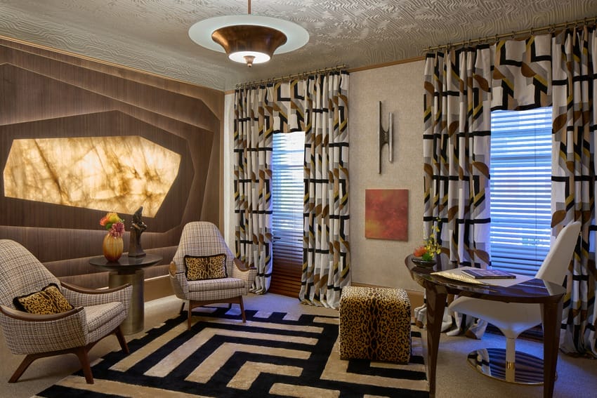 Modern living room with patterned curtains, geometric rug, and stylish chairs.