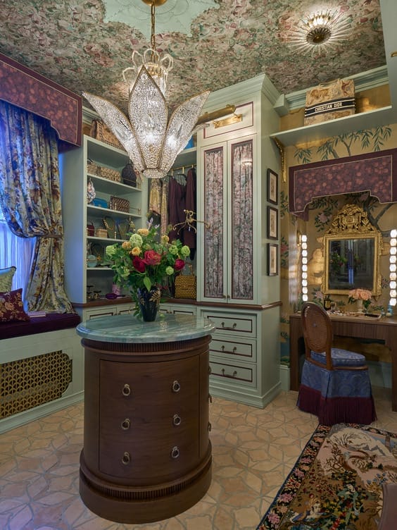 Luxurious vintage-style dressing room with floral decor, ornate chandelier, wooden vanity, and a bouquet on a round table.
