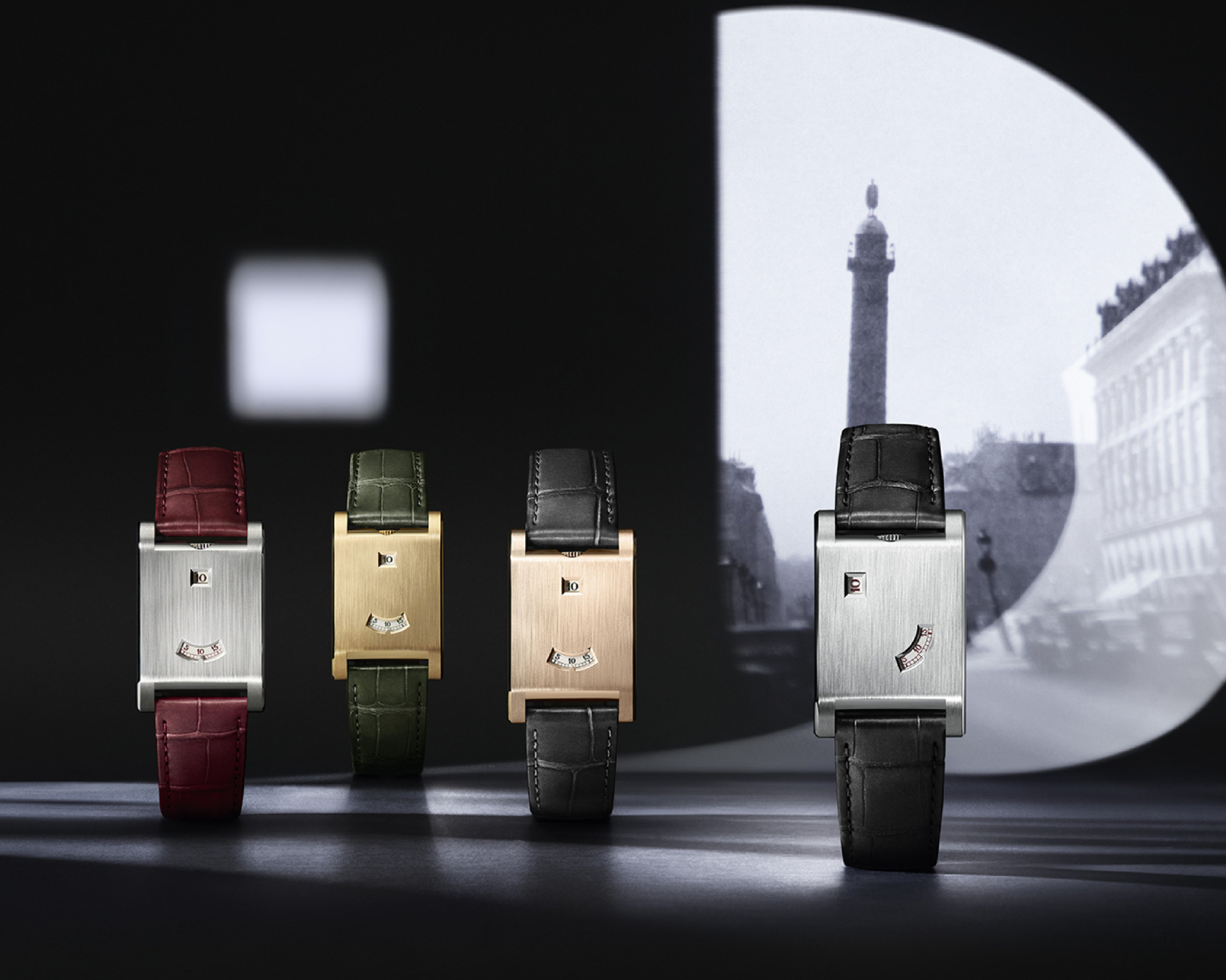 Four luxury rectangular watches with colored leather straps displayed against a monochrome city backdrop.