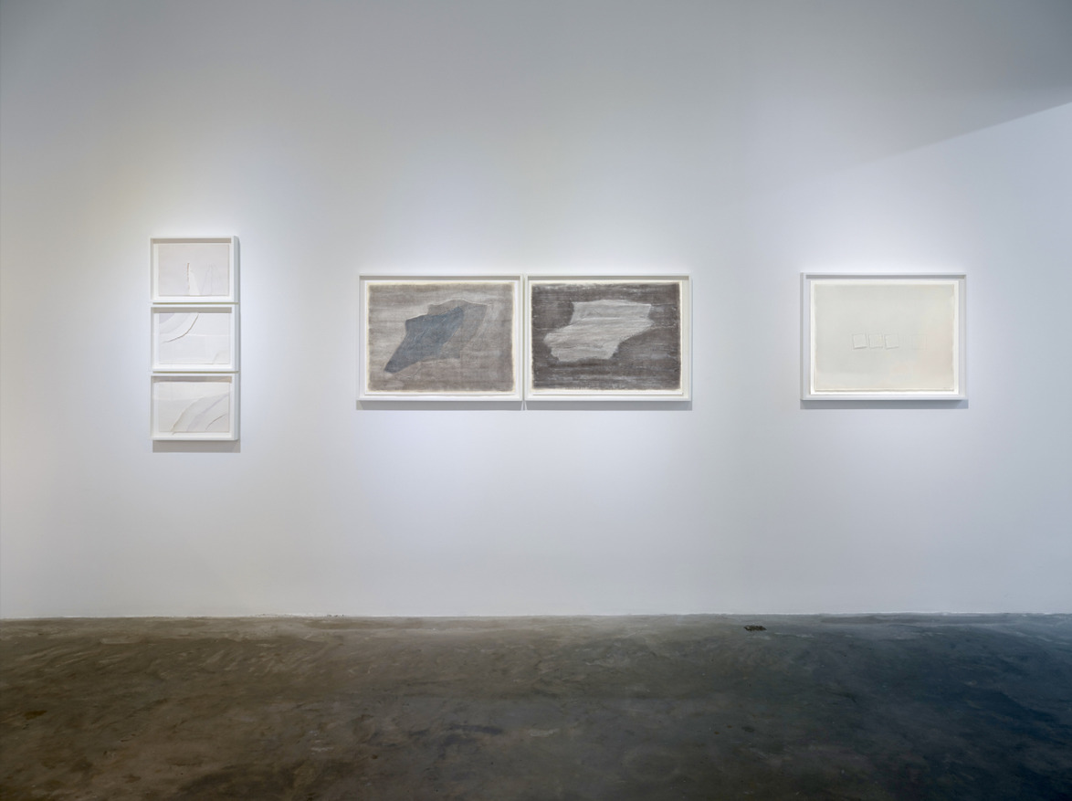 Art gallery with abstract drawings framed on a white wall, displayed in minimalist modern style.