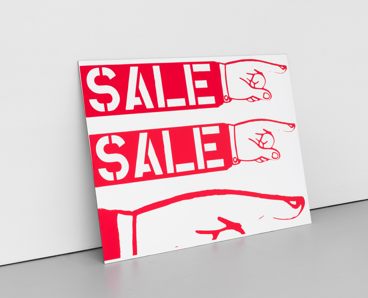 Poster with bold red text "SALE" and two pointing hands, leaning against a white wall.