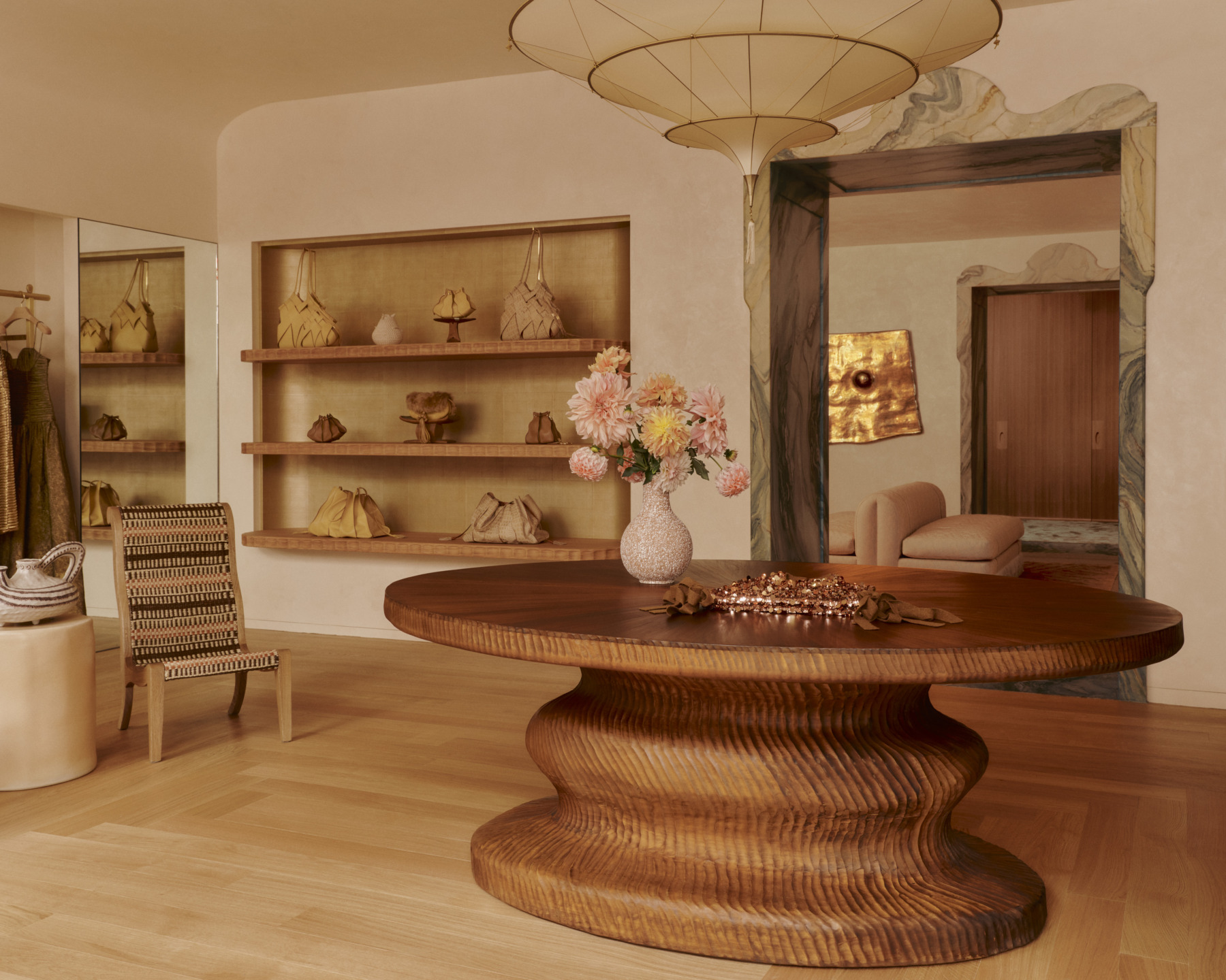 Elegant room with a round wooden table, tall chair, and softly lit decor.