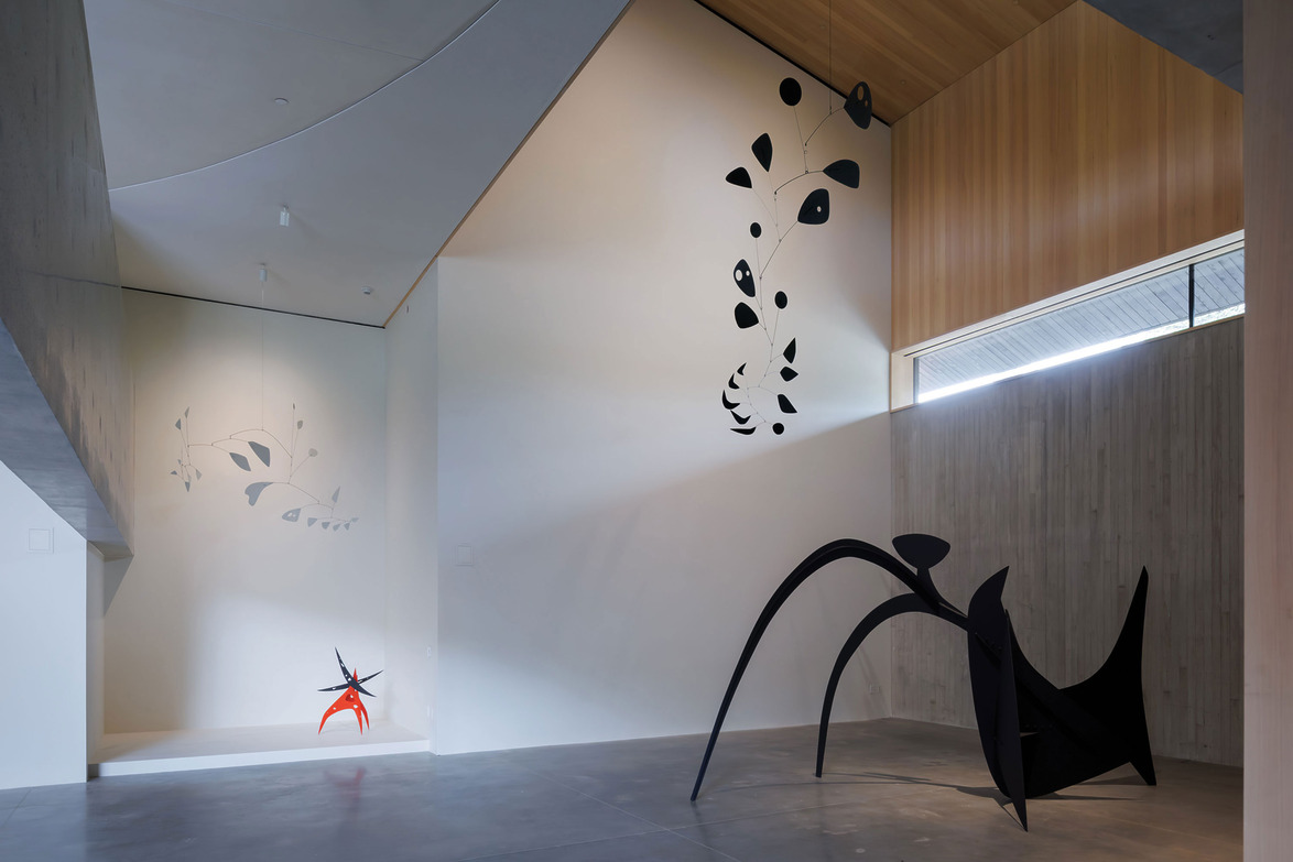 Contemporary art installation with modern abstract sculptures and wall designs in a spacious gallery setting.