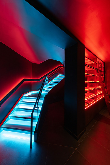 Futuristic staircase with glowing blue and red lights, modern architectural design.