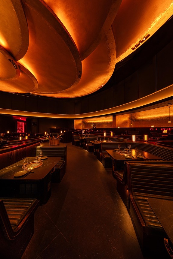 Elegant restaurant interior with dim lighting, modern design, and plush seating arrangements enhancing a cozy atmosphere.