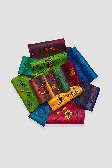 Colorful wooden blocks arranged in a circle, each painted with abstract designs and patterns in various bright shades.