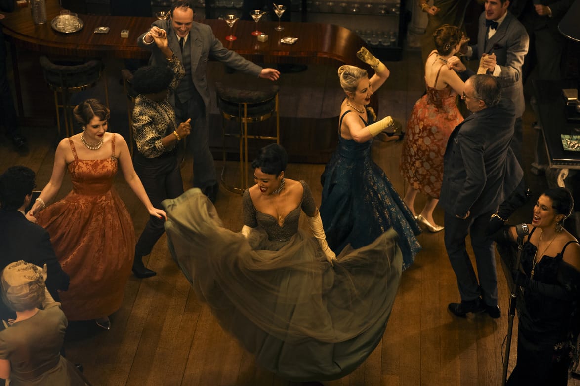 People dancing in a vintage-themed party with elegant outfits and a lively atmosphere.