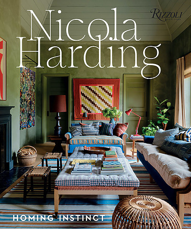 Cozy living room with colorful decor, including striped sofas, patterned rug, and books on a wooden coffee table.