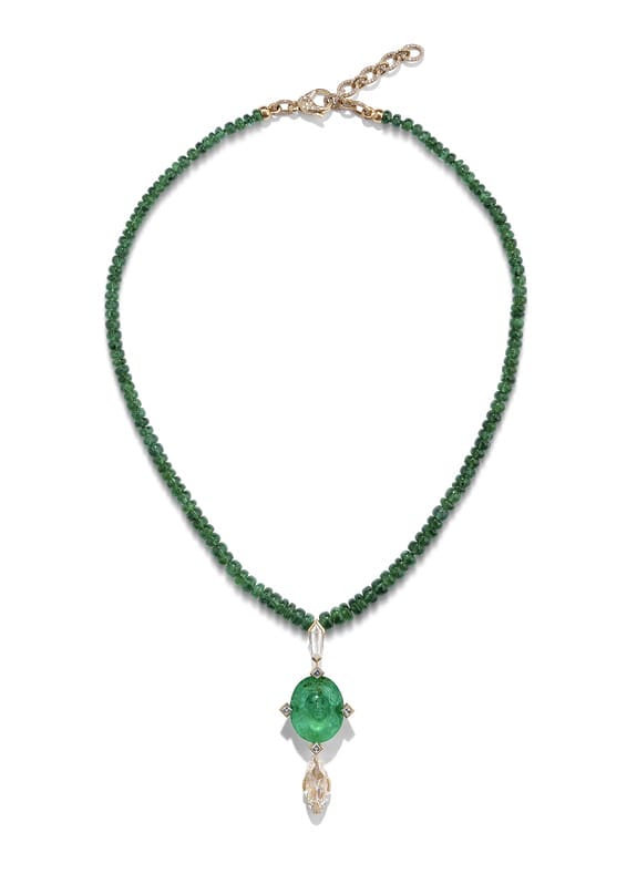 Emerald bead necklace with a large green pendant and a small clear drop, set on a white background.