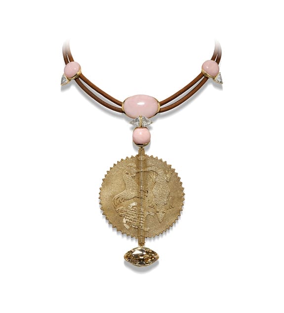 Gold pendant necklace with pink stones and a detailed centerpiece featuring an intricate design.